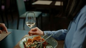 A meeting in a hotel restaurant Close-up of a guest enjoying a delicious seafood salad on a date with glass of white wine - Powered by Shutterstock - Get 15% off with code: PIKWIZARD15