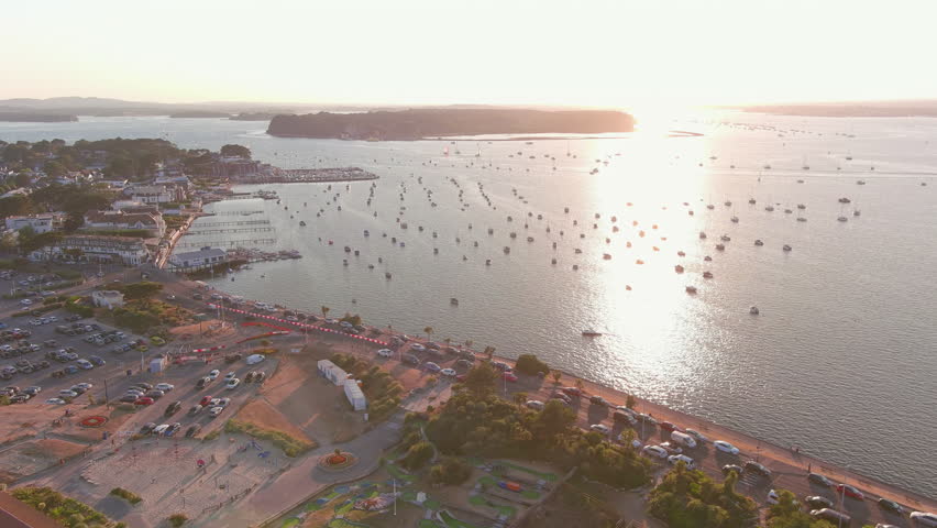Poole, UK: Aerial view of setting sun reflecting in sea surface in famous seaside resort city by Atlantic Ocean in England, Sandbanks neighbourhood in summer - landscape panorama of United Kingdom