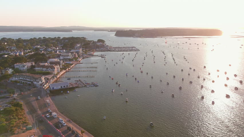 Poole, UK: Aerial view of setting sun reflecting in sea surface in famous seaside resort city by Atlantic Ocean in England, Sandbanks neighbourhood in summer - landscape panorama of United Kingdom