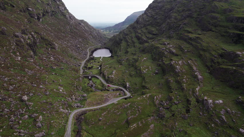 Spectacular 4K aerial video of flying above quirked mountain road, mountain pass and surrounded mountains with lakes