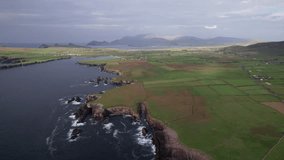 Wonderful 4K aerial video of flying above the Atlantic Ocean coastline with picturesque cliffs and rocks at evening