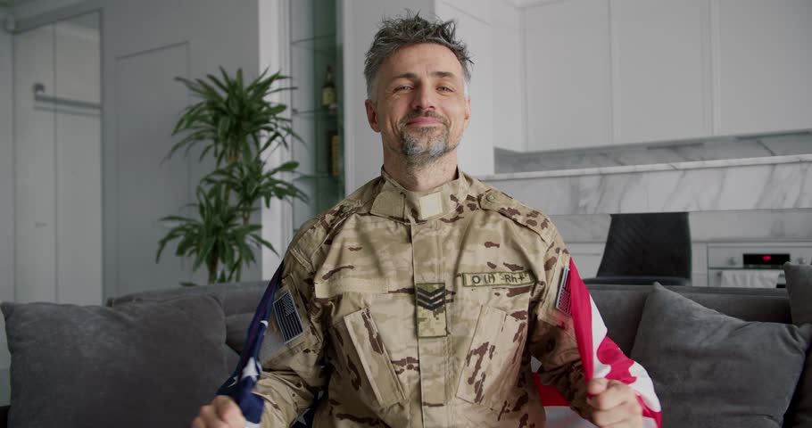 Portrait of a soldier who raises the American flag. Smile on your face, patriotism