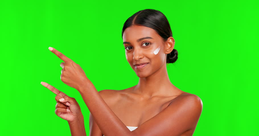 Beauty, lotion and a woman pointing on a green screen background in studio for natural skincare. Portrait, cream or antiaging treatment with a happy young female model advertising on chromakey mockup Royalty-Free Stock Footage #1103150973