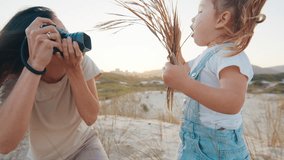 Family photographer. Woman with camera takes picture of the toddler girl outdoor - Powered by Shutterstock - Get 15% off with code: PIKWIZARD15
