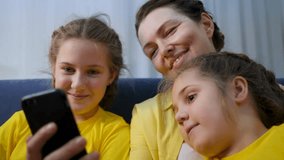Happy family at home children mom use mobile phone for leisure entertainment. Child, mom at home on couch sit look at phone. Use mobile for leisure entertainment while sitting at home with children. - Powered by Shutterstock - Get 15% off with code: PIKWIZARD15