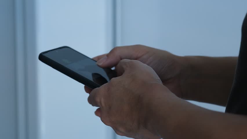 a man is typing on a smartphone secretly in the corner Royalty-Free Stock Footage #1103166271