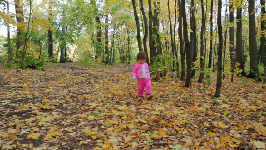 baby girl walking in autumn park 