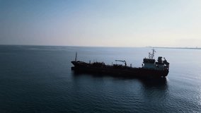 A ship sails into the sea. Red cargo ship in the blue sea. Barge afloat. The tanker sails into the sea. Blue sea. Video from the drone. 