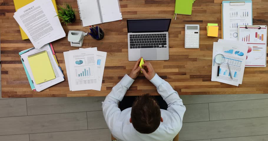 Businessman sticking lot of paper stickers on laptop and desk in office top view 4k movie