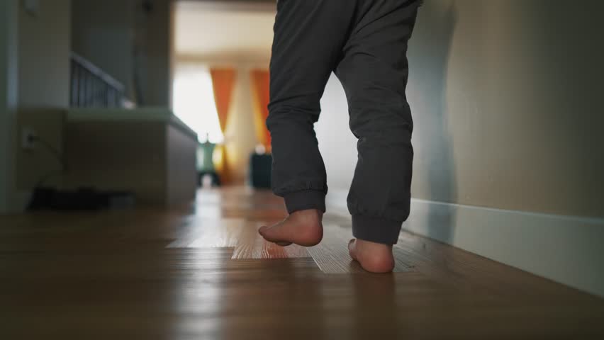 the child takes the first steps run on the floor to the father. bare feet of child run down the corridor. happy family kid dream concept. baby son run to his father hugs the first indoors steps Royalty-Free Stock Footage #1103168667