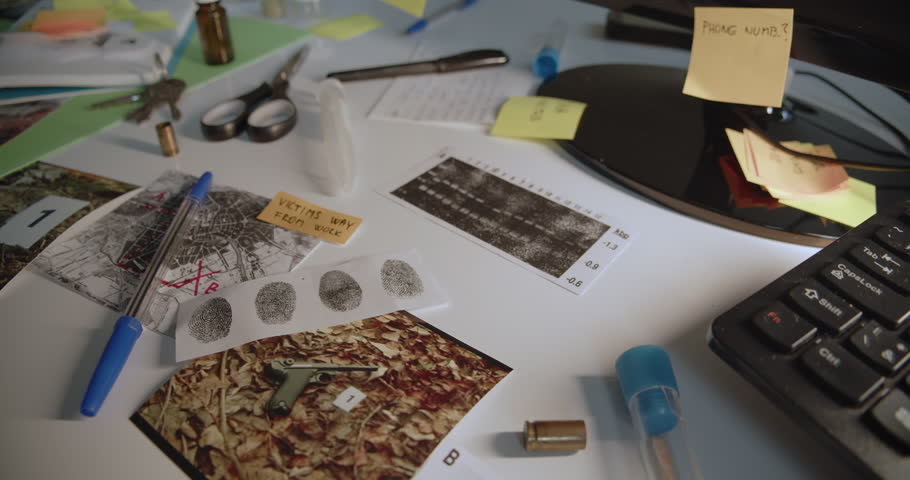Camera slowly reveals documents, photos, fingerprints, analysis and other evidence lying on the detective's desk or table