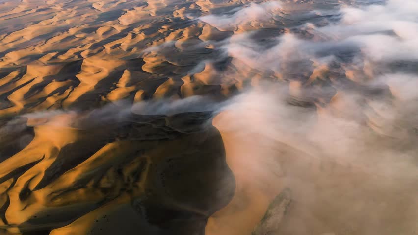 Aerial view titing over endless, Namib desert dunes, foggy morning in Namibia