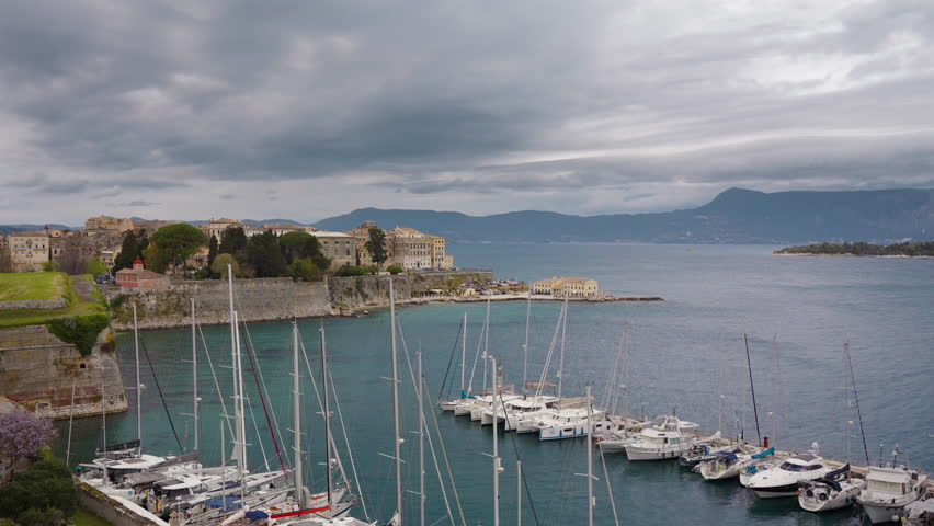 Old Corfu town cityscape, Greece. View to Kerkyra town from the Old Fortress. Yacht and boats harbor. 4k Timelapse.