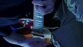 Man playing electric guitar, close up.Vertical video. Musician playing on guitar in recording studio, learning new chords. Close up of string on electric guitar. Guitarist playing song on guitar