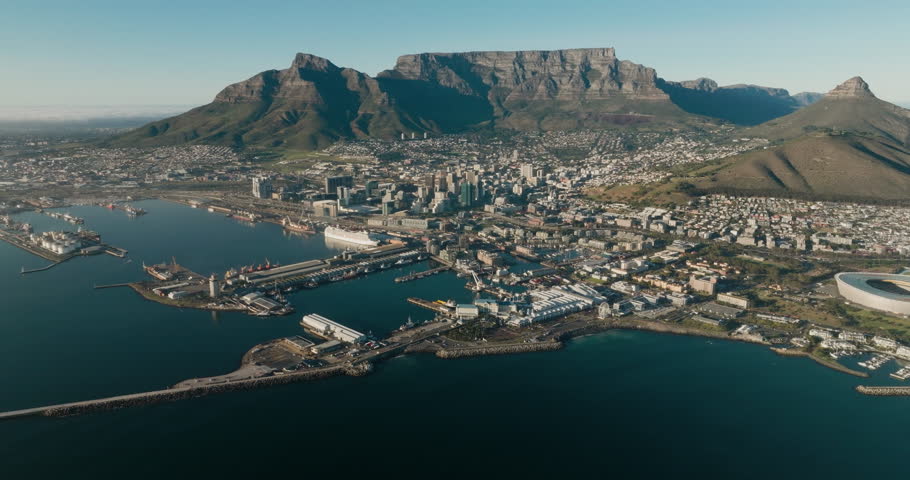 Spectacular high aerial fly over view of Cape Town Stadium, Waterfront, Harbour, City Centre, Table Mountain, Lion