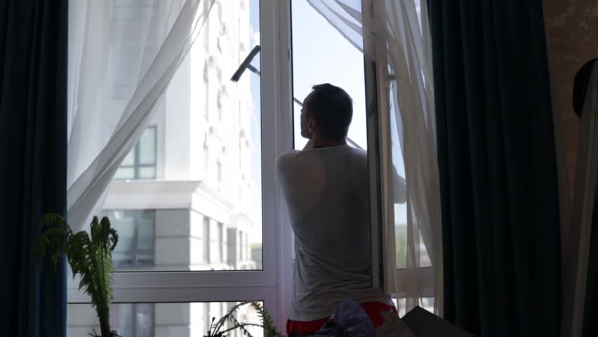 A professional cleaning service worker washes the windows with special foam and cleans them. Royalty-Free Stock Footage #1103184783