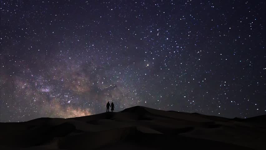 Time Lapse Milky Way Over Couple on Sand Dunes