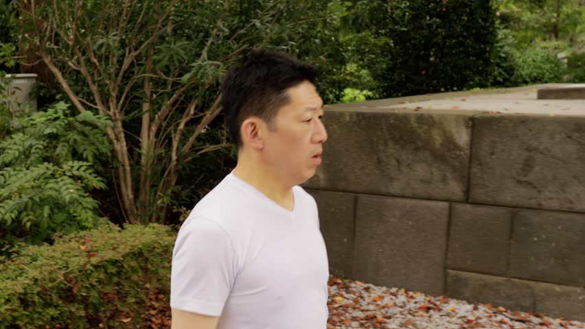 Middle-aged Japanese man exercises in a park in Tokyo Japan