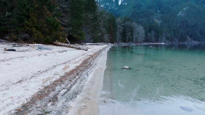 Flight along the coast of Chilliwack Lake in winter
