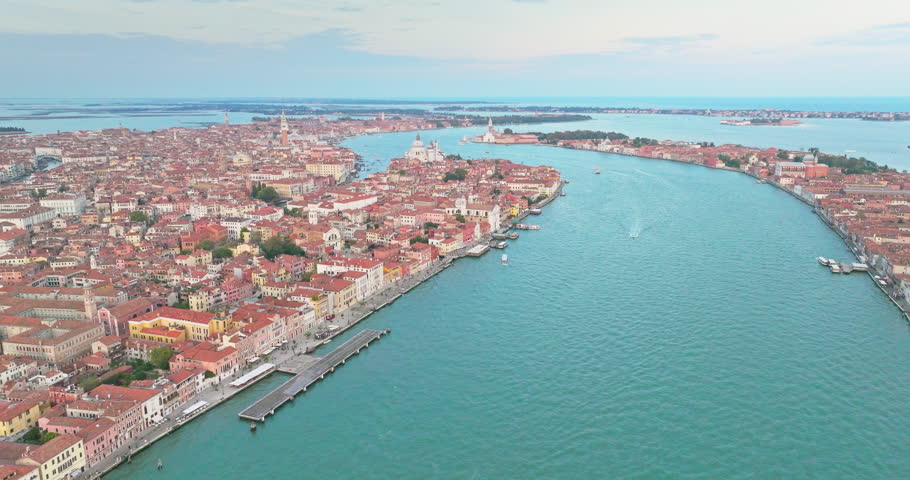 Aerial Sunset or Sunrise Shot of Central Venice city skyline, Italy. Panorama drone footage of famous tourist attraction from above. Basilica di Santa Maria della Salute, Grand Canal and lagoon.  Royalty-Free Stock Footage #1103189749