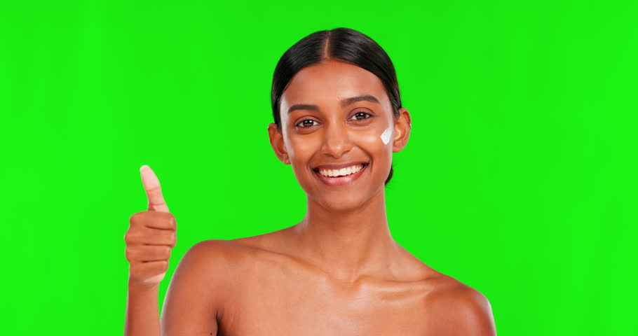 Skincare, cream and thumbs up with a woman on a green screen background in studio for natural beauty. Portrait, lotion or antiaging with a happy young female model in agreement on chromakey mockup Royalty-Free Stock Footage #1103191595