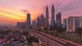 High angle aerial time lapse video of sunrise overlooking an urban village with busy expressway against Kuala Lumpur skyline in Malaysia. No Logo. High quality, Zoom out motion timelapse. Prores 4KUHD