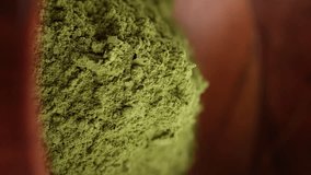 Sprinkle Matcha green tea powder in wooden bowl. Healthy drinks concept. Vertical video