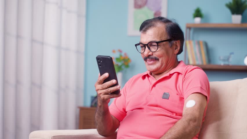 Elderly senior man checking glucose level by tapping smartphone to monitoring sensor at home - concept of health care, technology and mdicare. Royalty-Free Stock Footage #1103205741