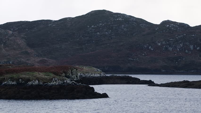 Shot of the opening to a salt water loch. The low tide line is visible with seaweed growing on the rocks. Filmed on the Isle of Lewis, part of the Outer Hebrides of Scotland.