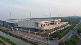Aerial Shot Rotating Around Distribution Warehouse with Windmills in the Background - Powered by Shutterstock - Get 15% off with code: PIKWIZARD15
