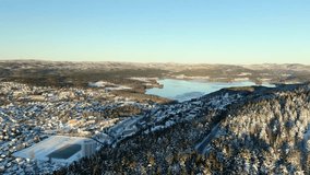 An aerial video of maridalen lake in Oslo, Norway in winter. The camera moves away from the lake, showing the snow-covered hills and trees. A tranquil footage for nature or winter themes. - Powered by Shutterstock - Get 15% off with code: PIKWIZARD15