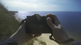 Photographer takes pictures on a cliff by the sea. Point of View Shot.POV video.