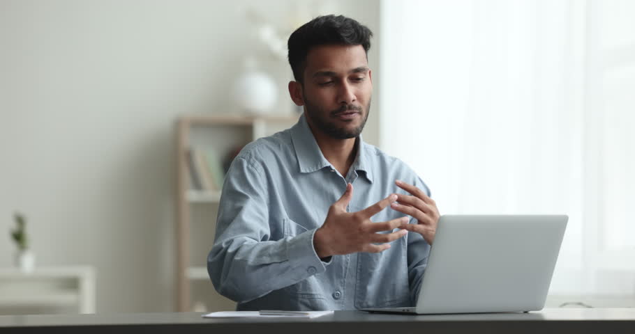 Young Indian man leads talk to client remotely, share information, gives advice, provide professional counselling on-line therapy remotely using video call app and laptop. Communication, modern tech Royalty-Free Stock Footage #1103218491
