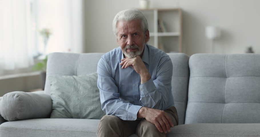 Portrait of happy grey-haired senior man sit on sofa smile look at camera, having attractive appearance enjoy carefree retired life relax at home. Medical insurance cover for older citizen, retirement Royalty-Free Stock Footage #1103218799