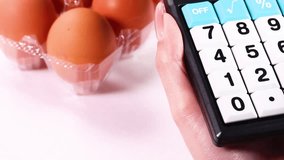 Eggs in a pack, woman using a calculator - Powered by Shutterstock - Get 15% off with code: PIKWIZARD15