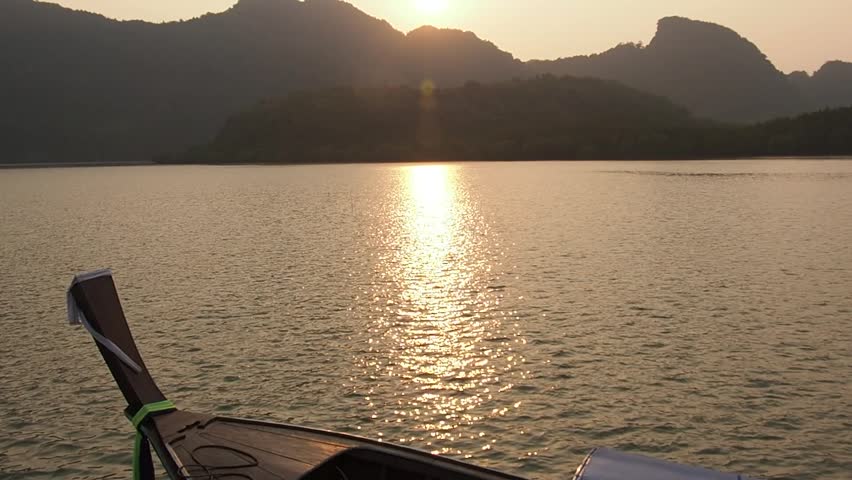 Sunset on the river, boat floats down the river to the sea ready to fish or return home late at night The sun splashes golden light, reflecting the beautiful waves.