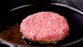 Sizzling Perfection: Delicious Hamburger Steak Cooking on Cast Iron Pan in High-Quality Stock Video Footage