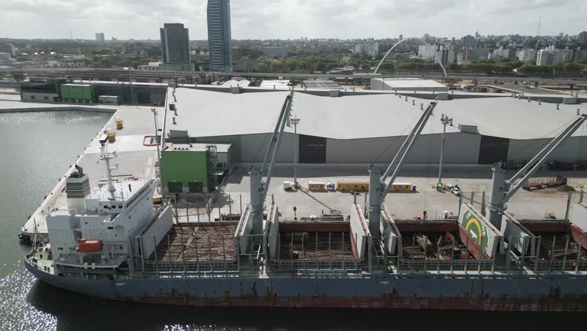 Panning across empty container crane ships anchored at the port of Montevideo, Uruguay