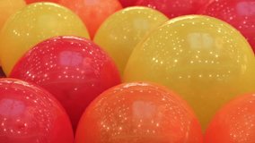 festive background of bouncing red, orange, yellow balls. closeup of a lot of bright balloons tightly pressed together moving up and down. selective focus. - Powered by Shutterstock - Get 15% off with code: PIKWIZARD15