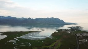 Aerial drone footage of an Icelandic green nature with a sea around Bodvegur bridge near Hofn during sunset at summer. High quality 4k footage