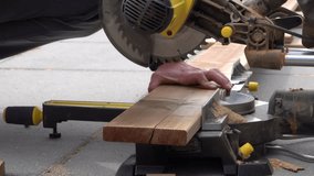 Man working with circular blade saw for cutting wood beam. Close up video clip of hand power tools.
