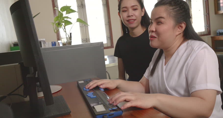 Happy Asian women co-workers in office workplace including person with blindness disability using computer with refreshable braille display assistive device. Disability inclusion at work concepts. | Shutterstock HD Video #1103240215