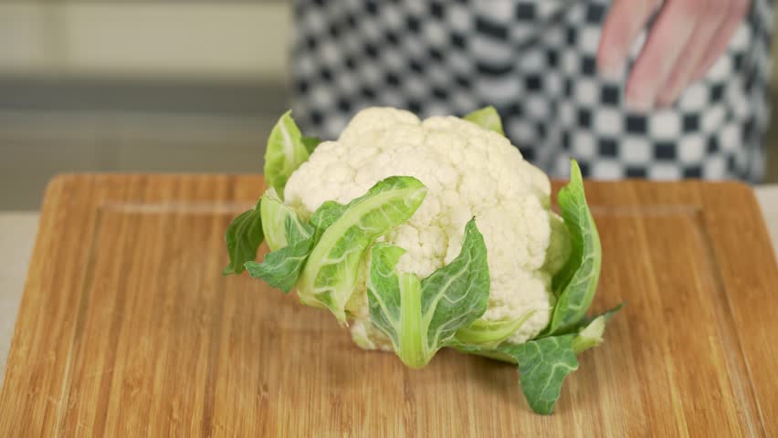 Chef peeling and cutting cauliflower on a wooden board Royalty-Free Stock Footage #1103240219