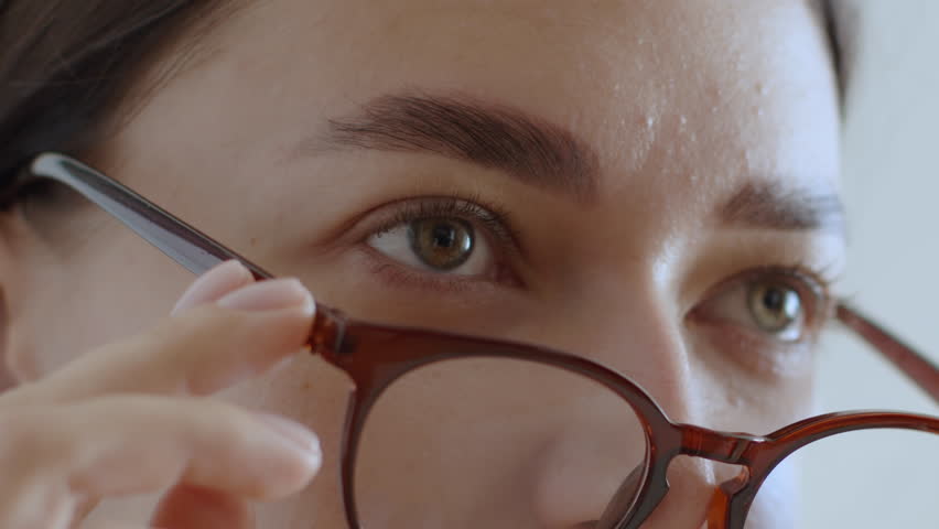 Eyesight problems. Close up portrait of young woman putting on eyeglasses and reading information on device, working with comfort Royalty-Free Stock Footage #1103241263