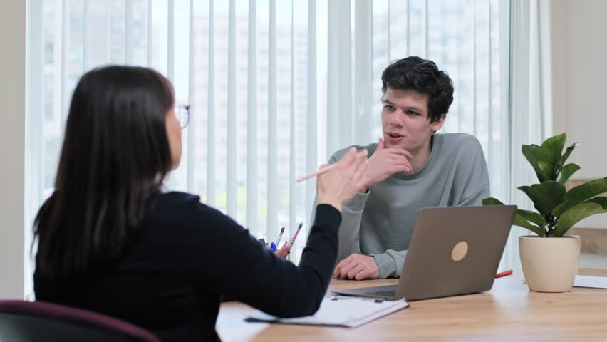 Guy student at therapy meeting with psychologist, mentor in college office | Shutterstock HD Video #1103241925