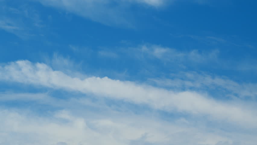 Beautiful cirrus cloud formations in a deep blue sky. Soft cirrus couds on blue sky. Time lapse.