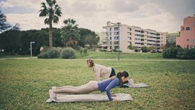 Strong athletes doing burpees workout at glade. Young active girls practicing high-intensity interval training together. Motivated women having cardio core strengthening exercise at spring fresh air - Powered by Shutterstock - Get 15% off with code: PIKWIZARD15