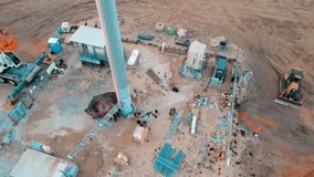 4k Drone video of the contruction site which is installing a cell tower with construction workers driving on heavy machinery equipment like excavators, bobcats, skid steers, and other heavy machinery