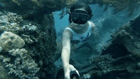 Young woman takes selfie underwater, clear blue sea. She swims below the water surface and looks at the camera. Female enjoying vacations in Croatia having fun exploring the underwater world - Powered by Shutterstock - Get 15% off with code: PIKWIZARD15