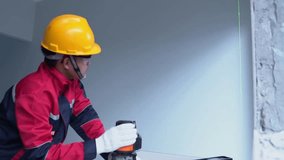 Asian worker working with digital laser level tool in home interior design. - Powered by Shutterstock - Get 15% off with code: PIKWIZARD15